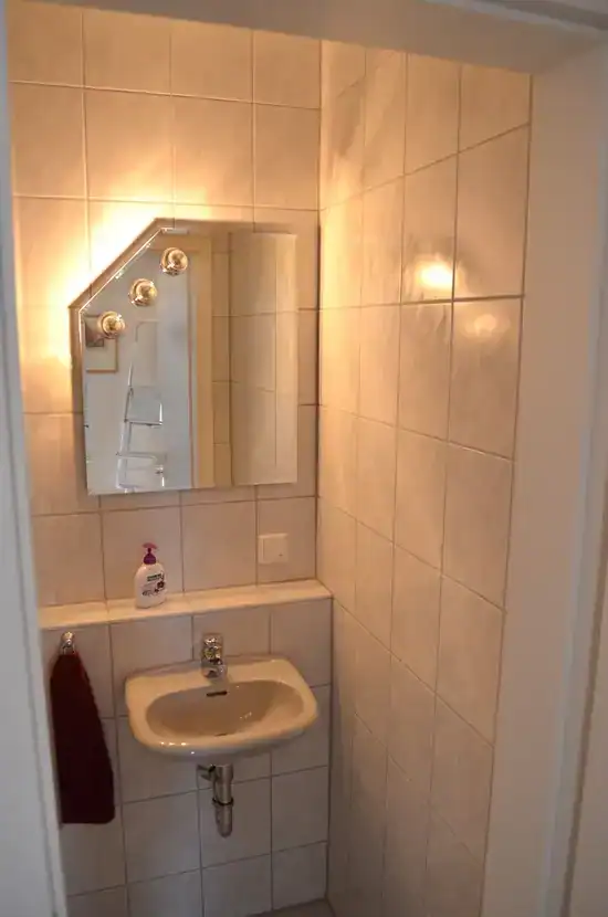 Kleines Badezimmer mit Waschbecken und Spiegel.