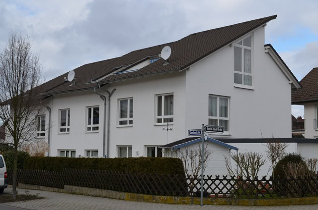 Weißes Gebäude mit Zaun in Wohngebiet