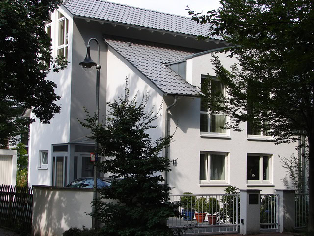 Modernes weißes Haus mit Satteldach und Garten