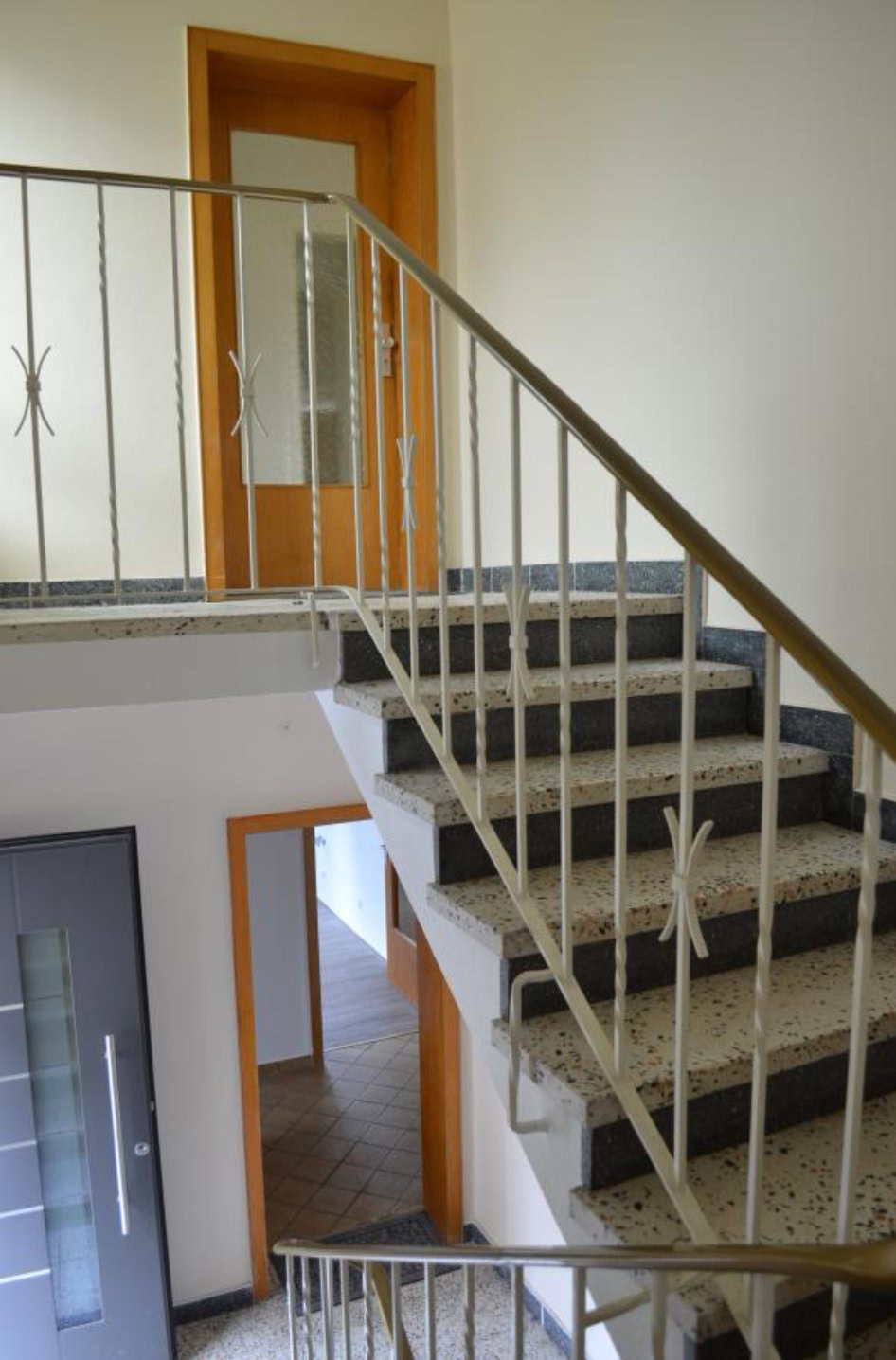 Treppenhaus mit Metallgeländer und Holztüren