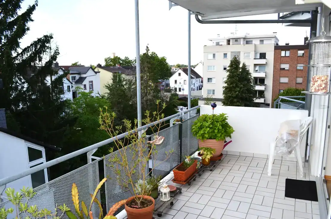 Balkon mit Pflanzen und Aussicht auf Wohnhäuser.