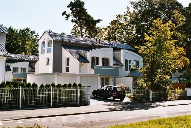 Modernes Einfamilienhaus mit Garten und Auto.