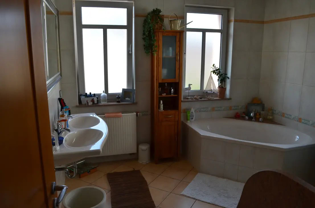 Modernes Badezimmer mit Eckbadewanne und Pflanzen