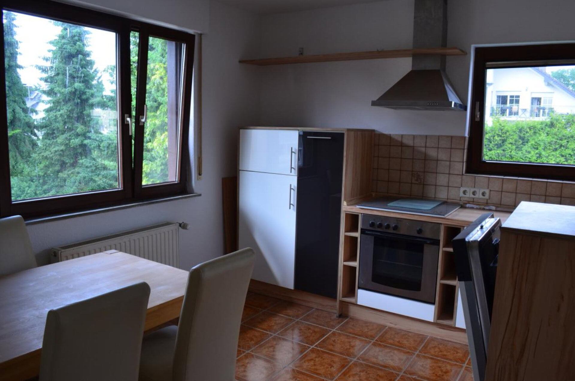 Moderne Küche mit Esstisch und großen Fenstern